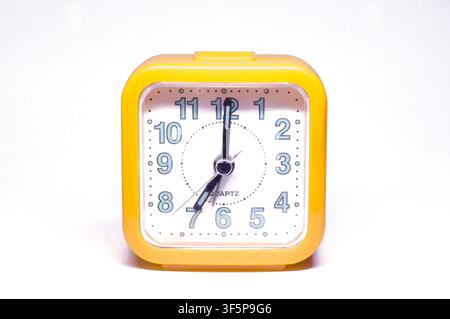 Yellow Retro Alarm Clock Showing 07:00 Time Isolated on Background Vintage Timepiece Stock Photo