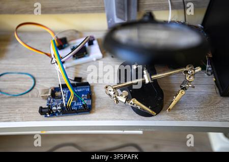 Electronic prototyping tools and hardware components on a workshop desk Stock Photo