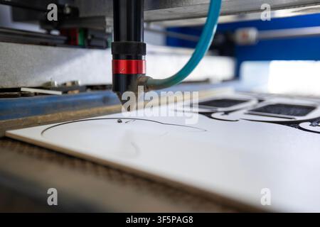 Cnc laser cutting machine for industrial manufacturing and precise plastic board shaping in a workshop setting using automated precision technology fo Stock Photo