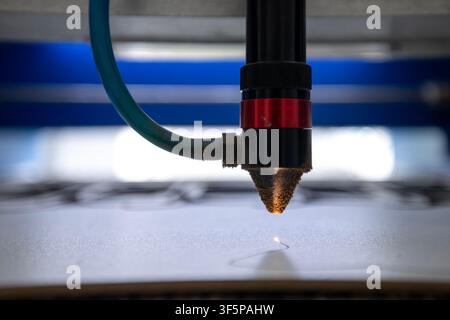 Laser cutting machine engraving details on flat material surface with high precision lens tool, industrial manufacturing equipment processing workspac Stock Photo