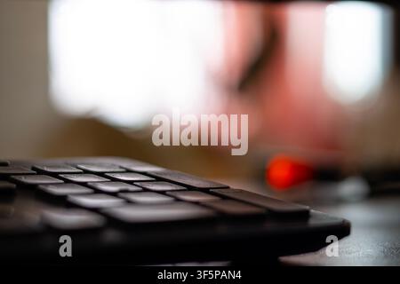 Computer keyboard close up with soft focus background in a home office setting blurred light and shadows casting on a desk surface creating a professi Stock Photo
