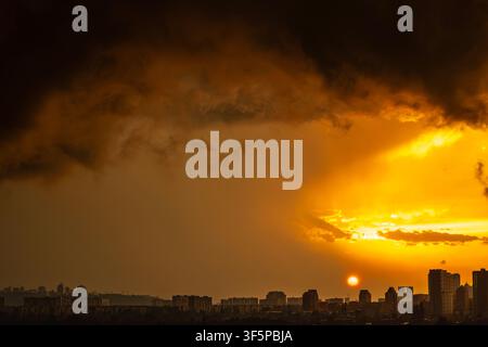 Kyiv, Ukraine cityscape Pechersk district silhouettes under a dramatic storm sky during golden hour with intense sunset light glowing over residential Stock Photo