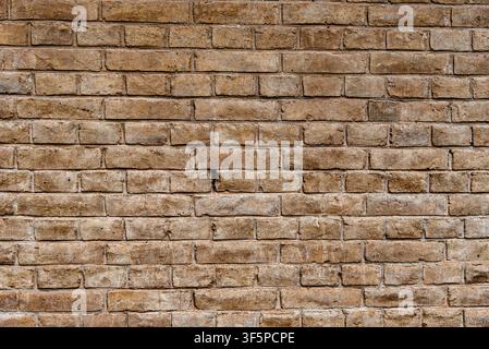Texture of an old brick wall made of light brown and beige bricks. The rough surface with natural imperfections is perfect as a background for archite Stock Photo