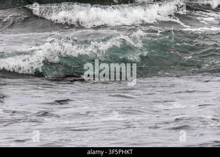 Ocean waves breaking over volcanic rocks on the coast of the Big Island Hawaii Stock Photo