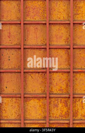 Rusty yellow metal grid panel background with red painted frame lines and heavy oxidation texture Stock Photo