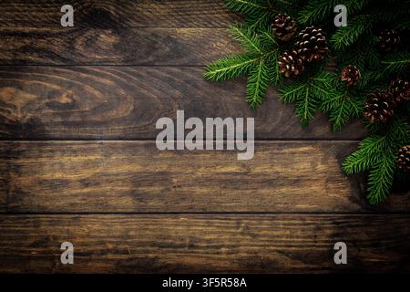 Christmas background with fir branches and pine cones on rustic wooden boards, christmas decoration Stock Photo