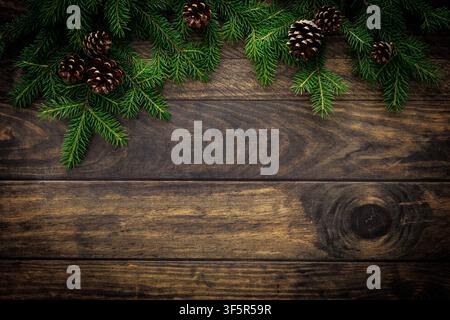 Christmas background with fir branches and pine cones on rustic wooden boards, christmas decoration Stock Photo