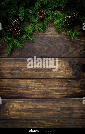Christmas background with fir branches and pine cones on rustic wooden boards, christmas decoration Stock Photo