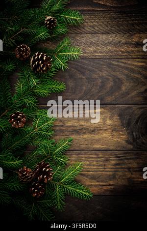 Christmas background with fir branches and pine cones on rustic wooden boards, christmas decoration Stock Photo
