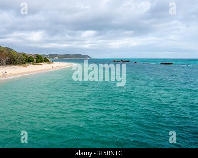 Scenic view of turquoise ocean, sandy beach, and distant Tangalooma shipwrecks Stock Photo