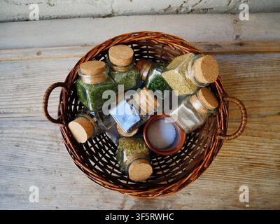 Top-Down Flat Lay of Glass Spice Jars with Cork Lids in a Round Wicker Basket Stock Photo
