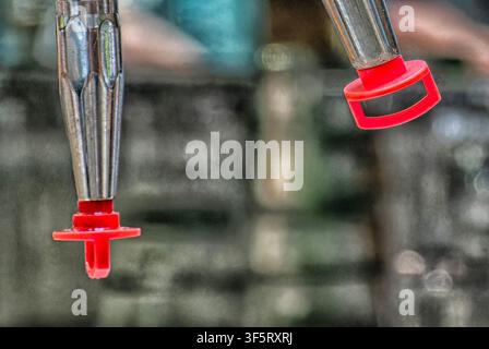A close-up view of a polished chrome beer dispenser, featuring a reflective surface and red faucet Stock Photo