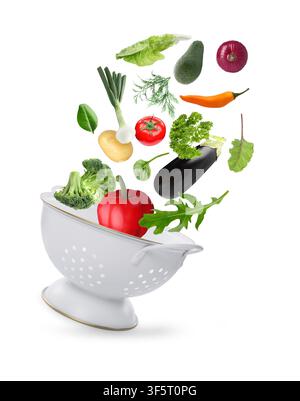 Fresh vegetables and colander in air on white background Stock Photo