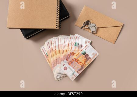 House keys, envelope, planner and Russian ruble banknotes on beige background. Mortgage payment, property purchase or home financing concept. Stock Photo