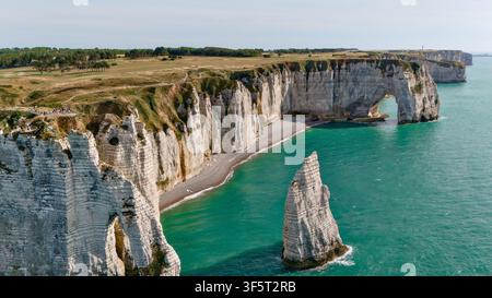 Aerial view of a dramatic sea stack rising from the ocean with waves ...