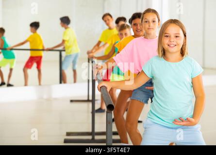 Group of smiling children practicing at ballet barre Stock Photo