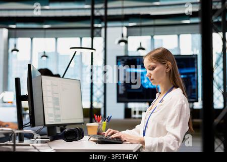 Female engineer developing applications using PC, integrating AI in office systems. Worker doing internship in tech startup debugging applications using artificial intelligence Stock Photo