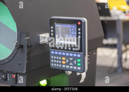 Industrial digital control panel with measurement system closeup, featuring small screen displaying coordinates and angles, function keys, numeric key Stock Photo