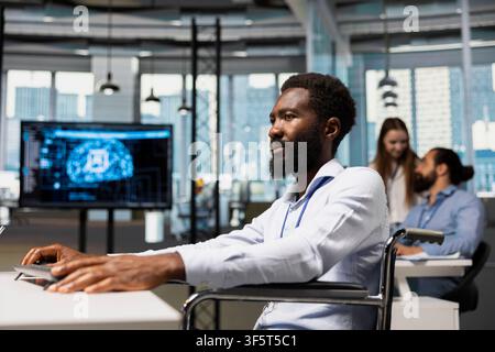 Software developer in wheelchair using AI automation, refining algorithms for faster processing. African american programmer with paraplegia using artificial intelligence for resource optimization Stock Photo