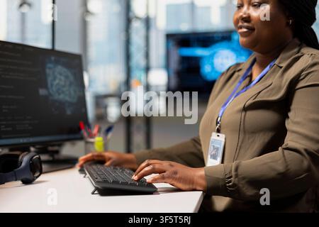 Close up of smiling admin adjusting machine learning algorithms parameters at work to automate tasks. Happy woman in tech startup working with AI driven insights for code optimization Stock Photo