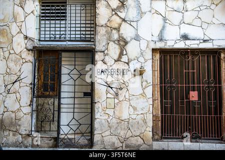 Havana, Cuba, Weathered Wooden Door and Window on an Ancient Old Building Facade with Barber Shop sign, Rustic Architectural Charm and Historic Vintag Stock Photo