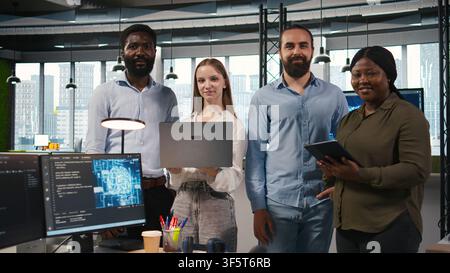 Portrait of smiling teamworking programmers utilizing AI to optimize performance and forecast issues. Cheerful coworkers in office training machine learning models, camera A Stock Photo