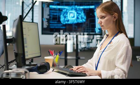 Junior developer optimizing performance using AI LLM chatbot recommendations. Young woman uses artificial intelligence assistant to convert manual workflows into automated scripts, camera A Stock Photo