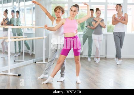 Ballet studio - teenagers girls and boys learn ballet movements in pairs Stock Photo