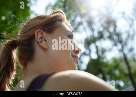 Smiling Woman Looking up during Outdoor Workout in Sunny Park Stock Photo