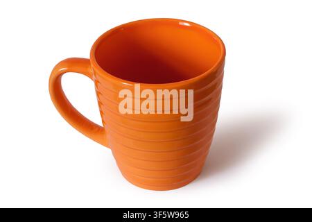 Empty ceramic cup on a white background. Orange cup close-up with shadow Stock Photo