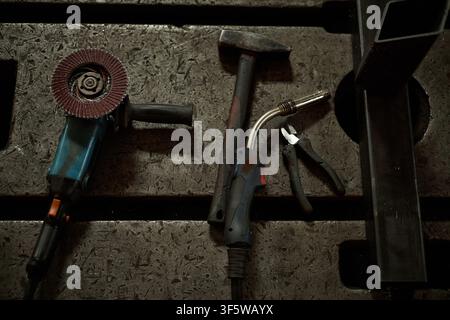 Industrial Welding and Grinding Tools Lying on Metal Workbench Stock Photo