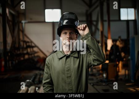 Portrait of Man Welder Holding Mask in Industrial Workshop Stock Photo