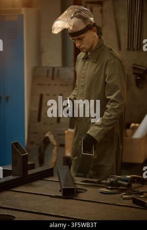 Male Welder in Protective Gear Working with Metal in Workshop Stock Photo