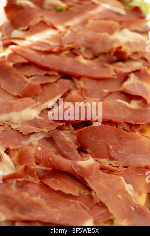 Thinly sliced cured ham creating a delicious pattern, ready to be served as an appetizer Stock Photo