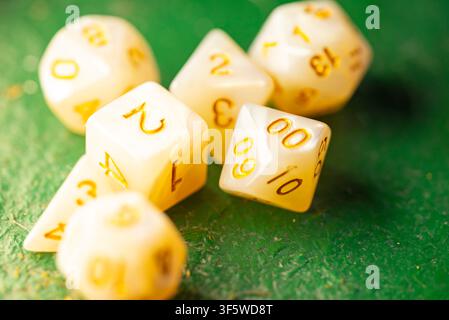 Close up of a polyhedral dice set resting on a green textured surface for tabletop role playing games Stock Photo