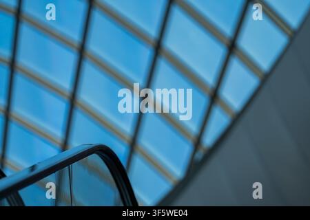 Abstract view of a modern glass roof with geometric metal framework and clear blue sky. Contemporary architectural background featuring clean lines, s Stock Photo