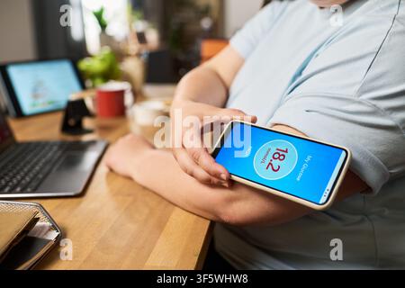 Woman Scanning Arm Cgm Sensor with Smartphone Showing High Glucose Level Stock Photo