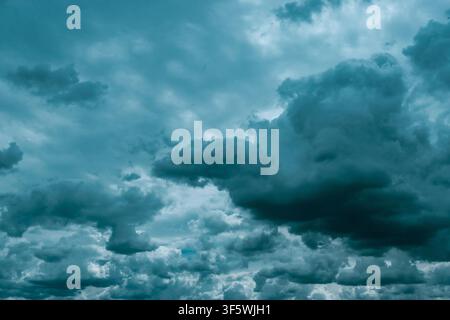 Dramatic layered storm clouds fill a grey sky above a distant horizon, creating a moody weather background Stock Photo
