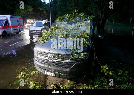 CNTV/UNFALL- Unfallort Polizei und Feuerwehr im Rettungs einsatz.Schweizer Grossfamilie wird in ihrem Transporter unter einem Baum eingeklemmt - E-Call System alarmiert die Rettungskräfte 04.08.2026 Hamburg - Eilbek Insgesamt 7 verletzte Personen Eine riesengroßen Schutzengel hatte eine sich auf Urlaub befindliche schweizer Großfamilie am Dienstag morgen im Hamburger Stadtteil Eilbek. Während der Fahrt stürzte in der Strasse Eilbektal aufgrund eines lokalen Unwetters ein riesiger Baum auf ihr Fahrzeug und zerstörte dabei den Bereich der Windschutzscheibe und des Daches vollständig. Die Familie Stock Photo
