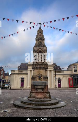 The Victorian Gothic style Drinking Fountain, featuring intricate Bible scenes, standing in Market Square under festive bunting in Saffron Walden. Stock Photo