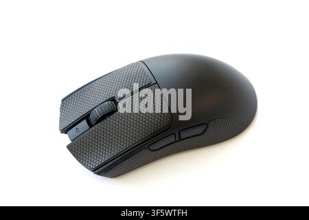 A modern black gaming mouse with textured grip surfaces is isolated against a clean white background Stock Photo