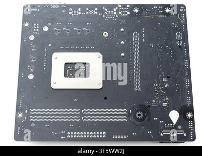 A close up view of the back side of a computer motherboard on a white background Stock Photo