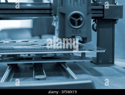 Process printing on 3D printer. The 3D printing process from molten plastic blue color. 3D printing technology. FDM technologies. Fused Deposition Modeling. Additive manufacturing. Stock Photo