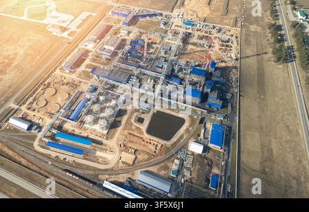Aerial view of an industrial plant with storage tanks, pipelines, and factory buildings surrounded by fields in Mogilev, Mogilev Region, Belarus. Stock Photo