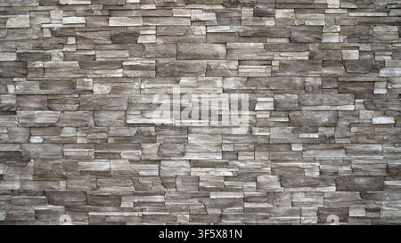 Closeup of stacked stone wall featuring layered rectangular stones in muted gray brown tones. Natural texture subtle lighting create depth Stock Photo