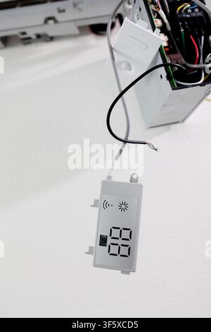Technician repairing air conditioner internal display module. HVAC system maintenance and electronics Stock Photo