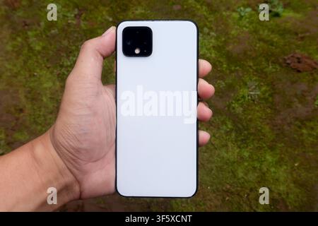 Hand Holding White Smartphone Back View Outdoors Stock Photo