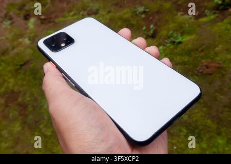 Hand Holding White Smartphone Back View Outdoors Stock Photo