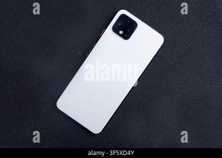 White Smartphone on Black Surface Background Stock Photo