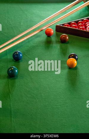 Snooker Table With Cues and Colored Balls On Green Felt Ready For Play In A Billiards Game Stock Photo